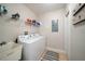 Functional laundry room with a washing machine, dryer, shelving, and utility sink at 17735 Gulf Blvd # 304, Redington Shores, FL 33708
