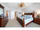 A well-lit bedroom featuring a king-size bed with ornate wood frame and ceiling fan at 17735 Gulf Blvd # 304, Redington Shores, FL 33708