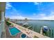 Channel view with a pier, boats, pool, and lush landscaping at 17735 Gulf Blvd # 304, Redington Shores, FL 33708