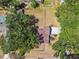 Overhead view of a property with lush trees providing shade, featuring a paved driveway and fence around the yard at 18902 Spring Hollow Dr, Lutz, FL 33559