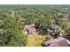 Aerial view capturing a home with a fenced backyard, storage, surrounded by lush trees and a neighborhood street at 18902 Spring Hollow Dr, Lutz, FL 33559