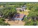 Aerial view of a fenced home with mature trees, a large yard, and neighboring houses in a tranquil residential setting at 18902 Spring Hollow Dr, Lutz, FL 33559