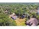 Aerial shot displaying a home with fenced yard, mature trees, a storage building and a glimpse of a neighborhood pool at 18902 Spring Hollow Dr, Lutz, FL 33559