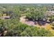Charming aerial view of a home nestled among trees, featuring a fenced yard and outbuilding, offering privacy at 18902 Spring Hollow Dr, Lutz, FL 33559