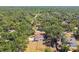 Capture an aerial shot of a home featuring a fenced yard, storage buildings, mature trees, and neighborhood views at 18902 Spring Hollow Dr, Lutz, FL 33559
