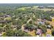 An aerial view of a neighborhood filled with lush greenery, mature trees, and well-spaced houses in a tranquil setting at 18902 Spring Hollow Dr, Lutz, FL 33559