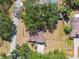 Aerial view of a charming single-story home with a brown roof surrounded by mature trees and a well-maintained lawn at 18902 Spring Hollow Dr, Lutz, FL 33559