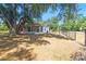 Rear view of a home showing a screened porch and fenced backyard with a large mature shade tree at 18902 Spring Hollow Dr, Lutz, FL 33559