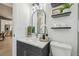 Modern bathroom with a vanity, elegant mirror, and decorative shelves with plants and storage at 18902 Spring Hollow Dr, Lutz, FL 33559