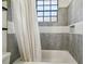 Stylish bathroom featuring a tub with gray tile surround and a window for natural light at 18902 Spring Hollow Dr, Lutz, FL 33559