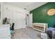 Bedroom with green accent wall, crib, and desk at 18902 Spring Hollow Dr, Lutz, FL 33559