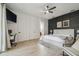 Spacious bedroom featuring wood floors, a stylish accent wall, and a ceiling fan at 18902 Spring Hollow Dr, Lutz, FL 33559