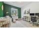 Bedroom with green accent wall, crib, changing table, and desk at 18902 Spring Hollow Dr, Lutz, FL 33559