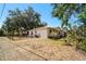 Side view of the white home with fenced in yard and mature trees at 18902 Spring Hollow Dr, Lutz, FL 33559