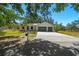 Scenic street view of a home with a well-maintained lawn and a convenient two-car garage at 18902 Spring Hollow Dr, Lutz, FL 33559