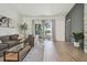 Bright living room featuring a comfortable couch, glass coffee table, and sliding glass doors to the outside at 18902 Spring Hollow Dr, Lutz, FL 33559