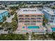 Aerial view of a condo building with a pool, hot tub, and beach access, set in a coastal neighborhood at 1912 Gulf Blvd # 305, Indian Rocks Beach, FL 33785