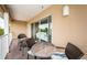 Balcony with mosaic table, wicker chairs and view of living room through sliding glass doors at 1912 Gulf Blvd # 305, Indian Rocks Beach, FL 33785
