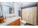 Well-lit bathroom with single sink vanity and shower featuring a map-themed shower curtain at 1912 Gulf Blvd # 305, Indian Rocks Beach, FL 33785