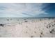 Scenic view of a sandy beach with people enjoying the ocean on a partly cloudy day at 1912 Gulf Blvd # 305, Indian Rocks Beach, FL 33785