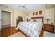 Comfortable bedroom features hardwood floors, a ceiling fan, and a dresser with a television at 1912 Gulf Blvd # 305, Indian Rocks Beach, FL 33785