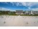 Exterior of condo building near a sandy beach and path with tropical beach foliage at 1912 Gulf Blvd # 305, Indian Rocks Beach, FL 33785