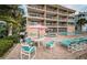 Exterior view of multi-story condo building with patios and lounge area featuring a pool and hot tub at 1912 Gulf Blvd # 305, Indian Rocks Beach, FL 33785