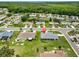 Aerial view of a charming neighborhood featuring well-maintained homes, lush landscaping, and a serene pond at 1915 W Del Webb Blvd, Sun City Center, FL 33573
