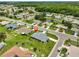 Overhead view of a residential area showcasing neatly arranged houses, green lawns, and a calm pond surrounded by trees at 1915 W Del Webb Blvd, Sun City Center, FL 33573
