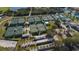Aerial view of a tennis court facility featuring multiple courts, shaded seating, and well-maintained green spaces at 1915 W Del Webb Blvd, Sun City Center, FL 33573