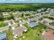 Aerial view of a residential area with neat lawns, tree-lined streets, and a tranquil pond nearby, ideal for families at 1915 W Del Webb Blvd, Sun City Center, FL 33573