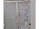 Bathroom showing tiled shower with sliding glass door and grab bars at 1915 W Del Webb Blvd, Sun City Center, FL 33573