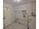 Laundry room with water heater, utility sink, and door at 1915 W Del Webb Blvd, Sun City Center, FL 33573