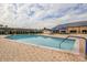 A large outdoor pool surrounded by a brick patio, lounge chairs, and covered seating areas, perfect for relaxation at 1915 W Del Webb Blvd, Sun City Center, FL 33573