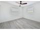 Bedroom featuring two windows, a ceiling fan, and gray wood-look floors at 200 Lewis Se Blvd, St Petersburg, FL 33705