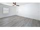 Bright bedroom featuring gray wood-look floors, a ceiling fan, and a window with blinds at 200 Lewis Se Blvd, St Petersburg, FL 33705
