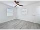 Bedroom featuring gray wood-look floors, two windows, and a ceiling fan at 200 Lewis Se Blvd, St Petersburg, FL 33705
