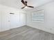 Bedroom featuring gray wood-look floors, a ceiling fan, a closet, and a window at 200 Lewis Se Blvd, St Petersburg, FL 33705