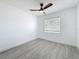 A bright bedroom featuring gray wood-look floors and a ceiling fan with a light at 200 Lewis Se Blvd, St Petersburg, FL 33705
