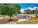Charming one-story home with a green front door, beautiful tree, and long driveway at 200 Lewis Se Blvd, St Petersburg, FL 33705