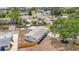An aerial view displays the home's new roof, driveway, fenced yard, shed, and mature shade tree at 200 Lewis Se Blvd, St Petersburg, FL 33705