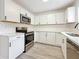 Modern kitchen with white cabinets, stainless steel appliances, subway tile backsplash, and wood grain floors at 200 Lewis Se Blvd, St Petersburg, FL 33705