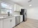 Bright kitchen featuring white cabinets, stainless steel appliances, subway tile, and wood grain floors at 200 Lewis Se Blvd, St Petersburg, FL 33705