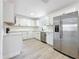 Bright kitchen featuring white cabinets, stainless steel appliances, subway tile, and wood grain floors at 200 Lewis Se Blvd, St Petersburg, FL 33705