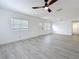 Bright living room with wood grain floors, a ceiling fan, white walls, and natural light at 200 Lewis Se Blvd, St Petersburg, FL 33705