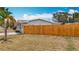 Side yard view with a wooden fence, green lawn, and mature trees adding privacy at 200 Lewis Se Blvd, St Petersburg, FL 33705