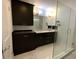 Modern bathroom with a double sink vanity, dark cabinets, and a glass-enclosed shower at 209 Rosery Rd, Belleair, FL 33756