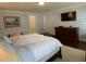 Comfortable bedroom featuring a large bed with a soft, white blanket and hardwood floors at 209 Rosery Rd, Belleair, FL 33756