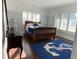 Inviting bedroom with a wooden sleigh bed, shuttered windows and an anchor-themed rug at 209 Rosery Rd, Belleair, FL 33756