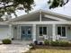 Inviting front exterior with blue double doors, lush landscaping and a covered porch at 209 Rosery Rd, Belleair, FL 33756